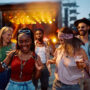 Cheerful friends dancing and having fun at summer music festival.