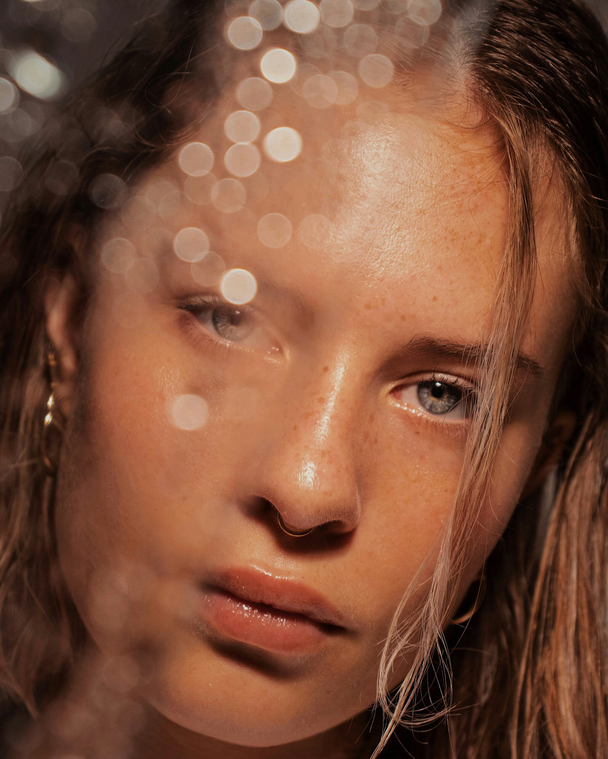 Woman applying lip gloss in a beauty routine at home during the daytime with natural light illuminating her face